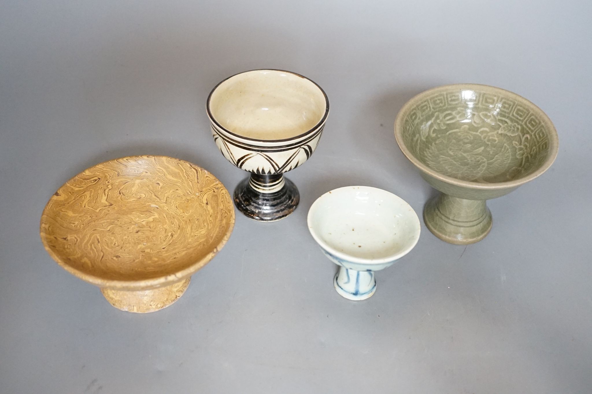 Four various Chinese pottery or porcelain stem cups, tallest 10cm